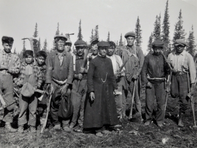Workers and Catholic priest at a construction site