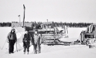 non-Cree men stand in front of a tractor sled train