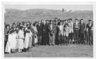 Cree people with a priest pose for a photo