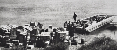 Cree men loading crates off a barge